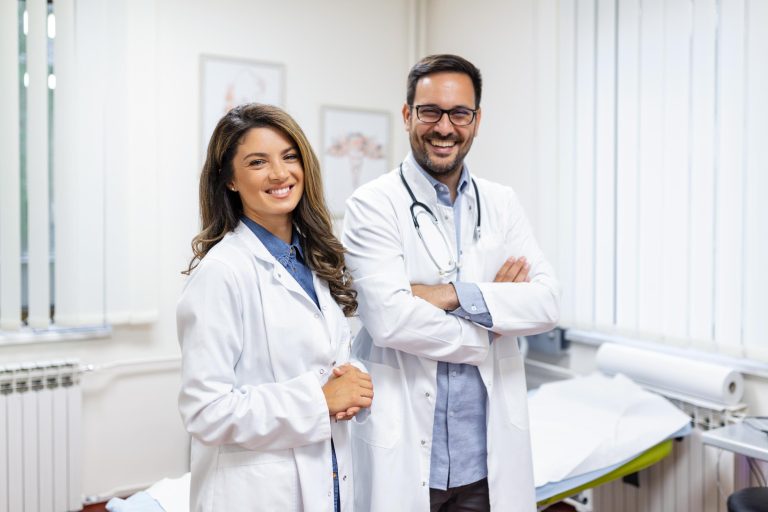 portrait-smiling-young-doctors-standing-together-portrait-medical-staff-inside-modern-hospital-smiling-camera